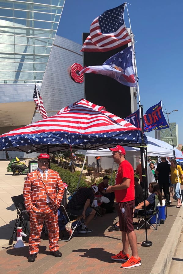Supporters of President Trump, including a man dressed as the border wall, line up outside outside an arena in Tulsa, Oklahoma, June 18, 2020, where the president will hold his first campaign rally in months this weekend .Despite the heat, the ever-growing risk of coronavirus and a lukewarm reception from local officials, dozens of backers of Trump are already camped out outside the arena (AP photo/ Tom McCarthy)