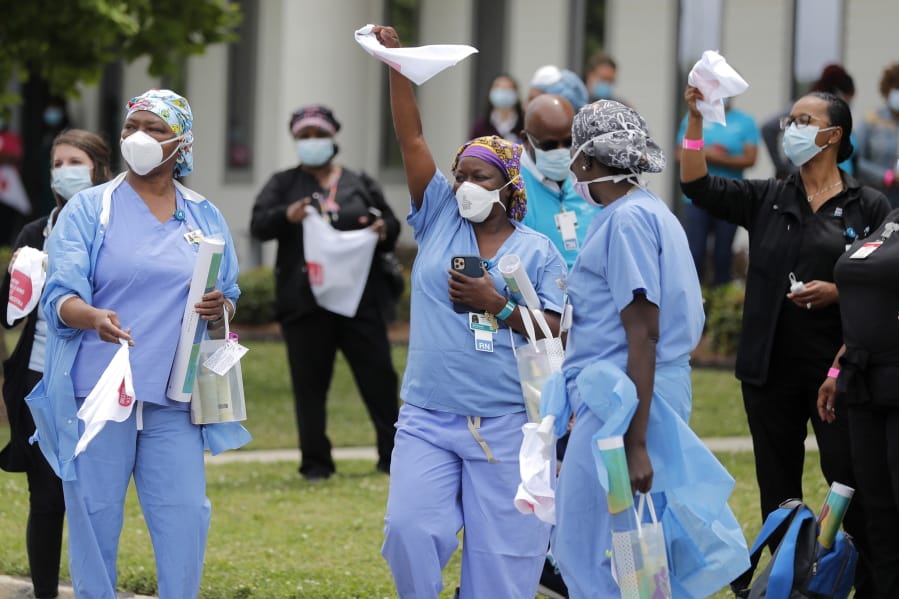FILE - In this May 15, 2020, file photo, healthcare workers at New Orleans East Hospital wave handkerchiefs and dance to a jazz serenade, as a tribute for their care for COVID-19 patients, by the New Orleans Jazz Orchestra, outside the hospital in New Orleans. An act of generosity or self-sacrifice. A whimsical gesture to distract neighbors from anxiety or cabin fever. A helping hand to a person thrown out of a job, support for a patient struggling with COVID-19, solidarity with the medical professional toiling day and night to save them. Nearly three months later, there&#039;s been no end to the tales of good deeds we&#039;ve found.