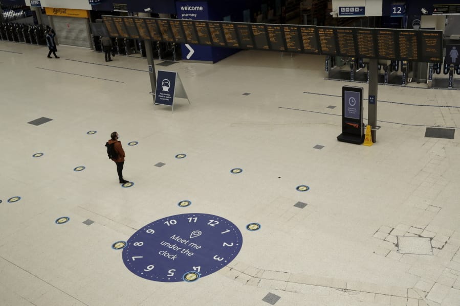 Social distancing guidelines on the floor by train departure information screens to help stop the spread of coronavirus in Waterloo station, London, Thursday, June 4, 2020. Waterloo station, which is wide recognised as the busiest train station in Britain, is still much quieter than normal as most commuters are working from home and not commuting into central London offices.