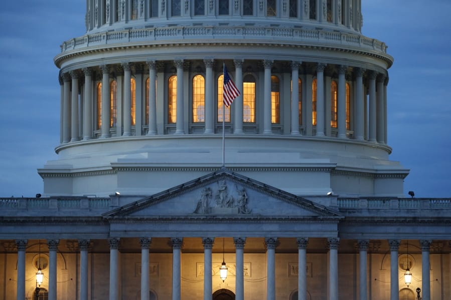 FILE - In this May 3, 2020, file photo, light shines from inside the U.S. Capitol dome at dusk on Capitol Hill in Washington.