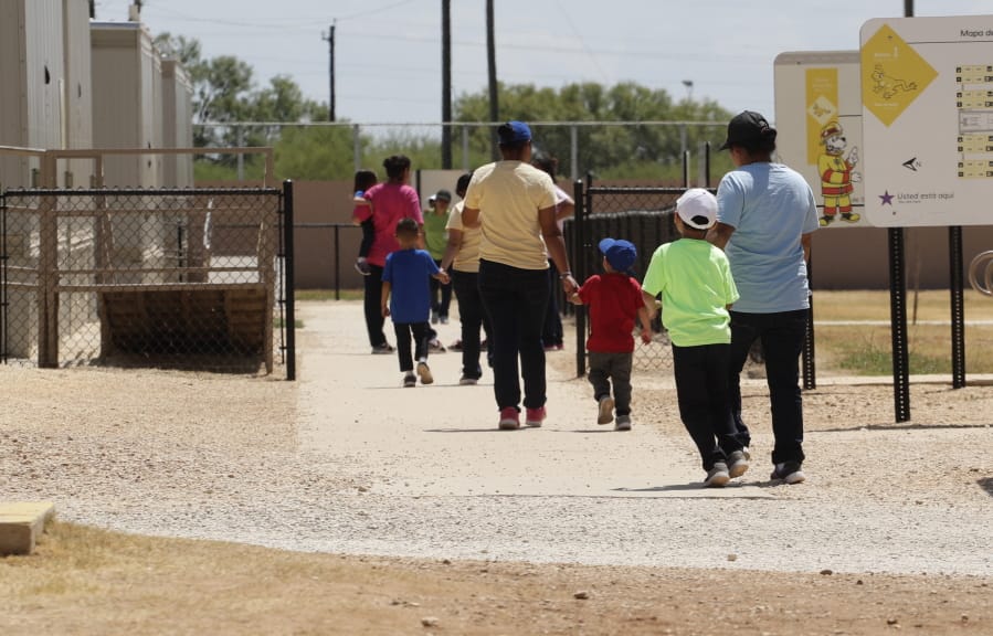 FILE - In this Aug. 23, 2019 file photo, immigrants seeking asylum hold hands as they leave a cafeteria at the ICE South Texas Family Residential Center in Dilley, Texas. The isolation of at least three families at the U.S. Immigration and Customs Enforcement&#039;s detention center in Dilley, has raised new fears of the coronavirus spreading through a facility that has long been accused of providing substandard medical care.