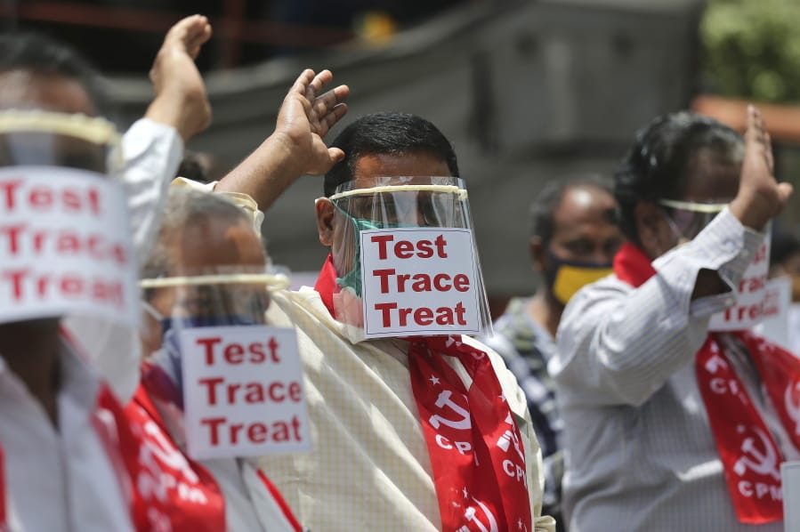 Activists of Communist Party of India Marxist display placards on face shields and shout slogans during a protest asking the state government to increase testing and free treatment for all COVID-19 patients in Hyderabad, India, Monday, June 29, 2020. Governments are stepping up testing and warily considering their next moves as the number of newly confirmed coronavirus cases surges in many countries. India reported more than 20,000 new infections on Monday.