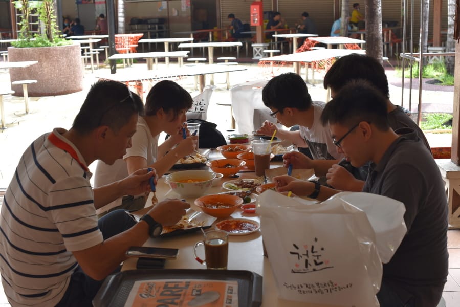 A group of five people have lunch together at the Newton Food Center Friday, June 19, 2020, in Singapore. Singaporeans can now wine and dine at restaurants, work out at gyms and get together with five people or less after most lockdown restrictions were lifted Friday.