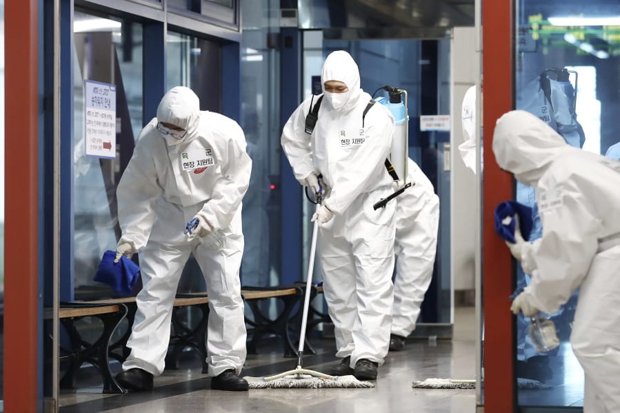 South Korean soldiers wearing protective gears disinfect as a precaution against the new coronavirus at a train station in Daejeon, South Korea, Thursday, June 25, 2020.