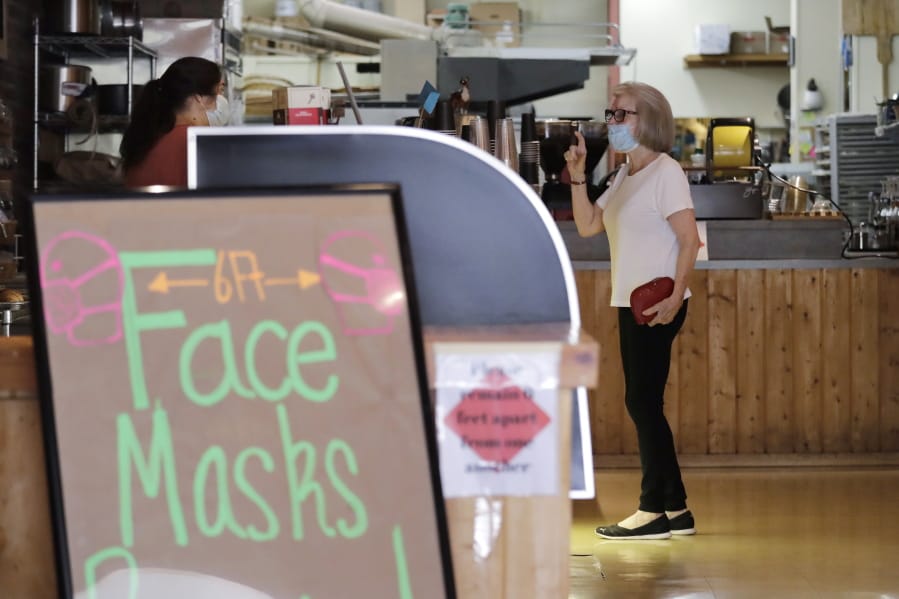 A customer, wearing a mask because of the coronavirus outbreak, puts in an order at a bakery Wednesday, June 17, 2020, in Yakima, Wash. Yakima, Benton and Franklin counties remain in Phase 1, meaning only essential businesses are open; restaurant service is limited to takeout and delivery; and limited outdoor recreation.