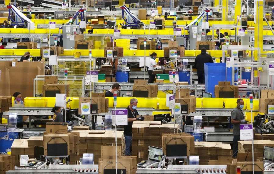 Employees at packing stations are seen at Amazon&#039;s Kent fulfillment center, where parts of the company&#039;s coronavirus response have been tested, on June 11, 2020.