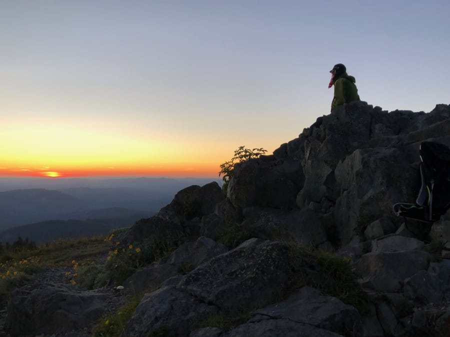 A hiker takes in the sunset atop Silver Star Mountain. At more than 4,300 feet elevation, the view stretches from Mount Rainier to the north to Mount Jefferson to the south.