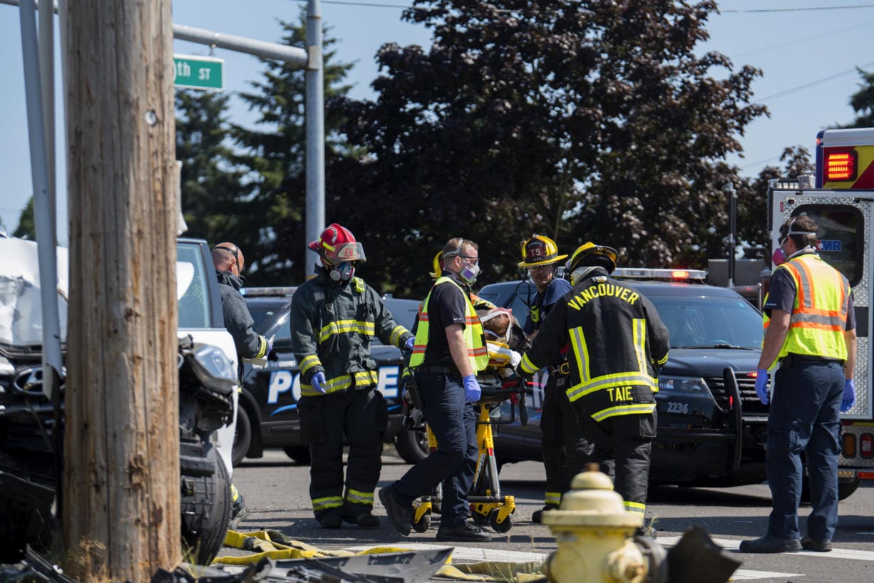 First responders load a person into a waiting ambulance as three people were injured in a two-vehicle crash at the intersection of Southeast Ellsworth Road and Southeast 10th Street on Wednesday morning, July 29, 2020.