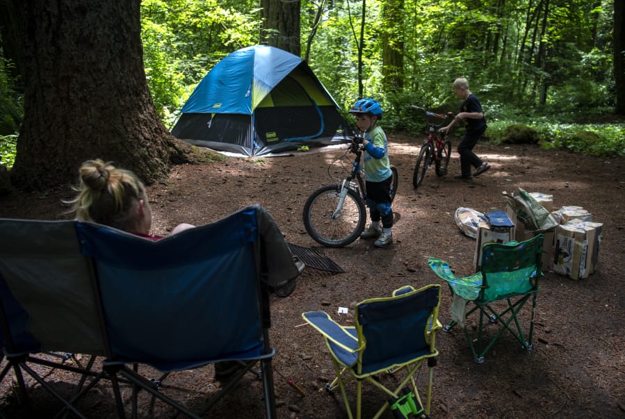 Jack Thompson, 5, of Kingston chats with his mom before taking off on his bike with a new friend from the adjacent campsite at Battle Ground Lake State Park in June. The campground is now open with some distancing restrictions in the group areas. Jack&#039;s mom, Leah, said their family had reservations at other campsites but they were canceled due to closures with the pandemic.