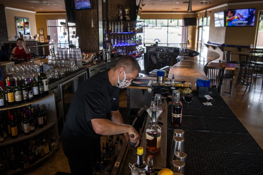 Steve Hilken, restaurant co-owner, makes drinks at Main Event&#039;s east location. During Phase 2 of reopening, restaurants must keep a 6-foot distance between tables. Main Event has eliminated bar seating and added one small table next to the bar.