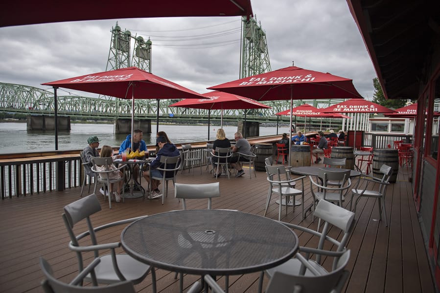 Customers at Who Song &amp; Larry&#039;s practice social distancing while enjoying lunch with a Columbia River view on Tuesday. Owners of the restaurant intend to stay in the location until at least 2041.