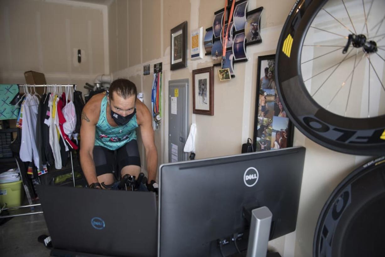 Joshua Monda demonstrates how he virtually rides his bike through London in the garage of his Vancouver home Wednesday afternoon, July 22, 2020.