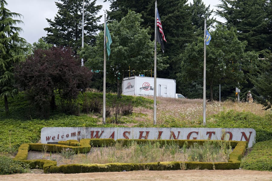 The &quot;Welcome to Washington&quot; sign that greets motorists as they enter Vancouver on Interstate 5, which usually features a colorful floral display, has become overgrown with weeds. The COVID-19 pandemic prevented the normal spring replanting of the sign&#039;s flower bed.
