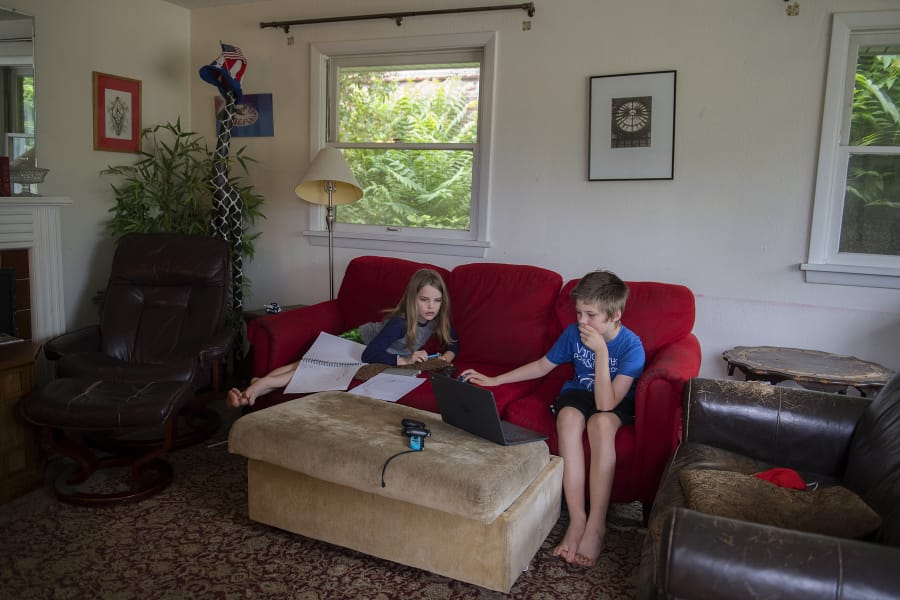 Aaron Hamann, 9, left, pauses to check out a video being created by his brother, Steven Hamann, 11, at their Vancouver home Thursday. The kids are staying busy by working on unique passion projects during a time they&#039;d normally be doing sports and other summer activities. Research suggests the summer doldrums can take an academic hit on children, exacerbated by the challenges of the COVID-19 pandemic.