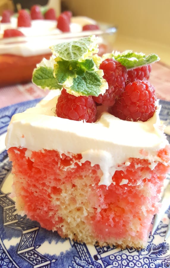 This raspberry poke cake has pockets of raspberry flavor made by poking holes in the cake while it&#039;s still warm and filling them with raspberry gelatin.