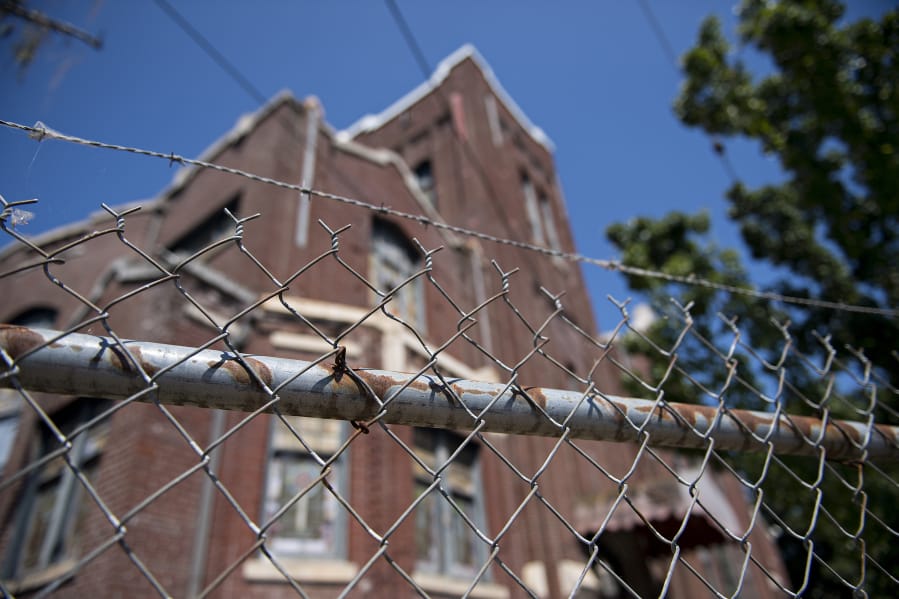 A fence surrounds the old church at 400 W. Evergreen Blvd., where loose bricks could pose a hazard to pedestrians.