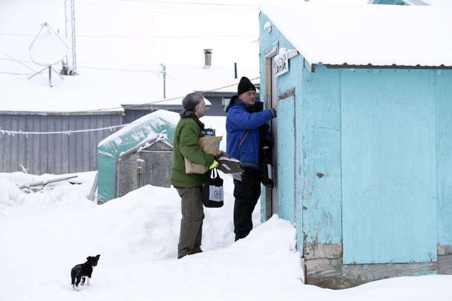 FILE - In this Jan. 21, 2020, file photo, Census Bureau director Steven Dillingham, right, knocks on the door alongside census worker Tim Metzger as they arrive to conduct the first enumeration of the 2020 Census in Toksook Bay, Alaska. Thousands of census takers are about to begin the most labor-intensive part of America&#039;s once-a-decade headcount. The 2020 census started in January in rural Alaska where census takers visited homes much earlier than the rest of the country because of the difficulty in reaching those places.