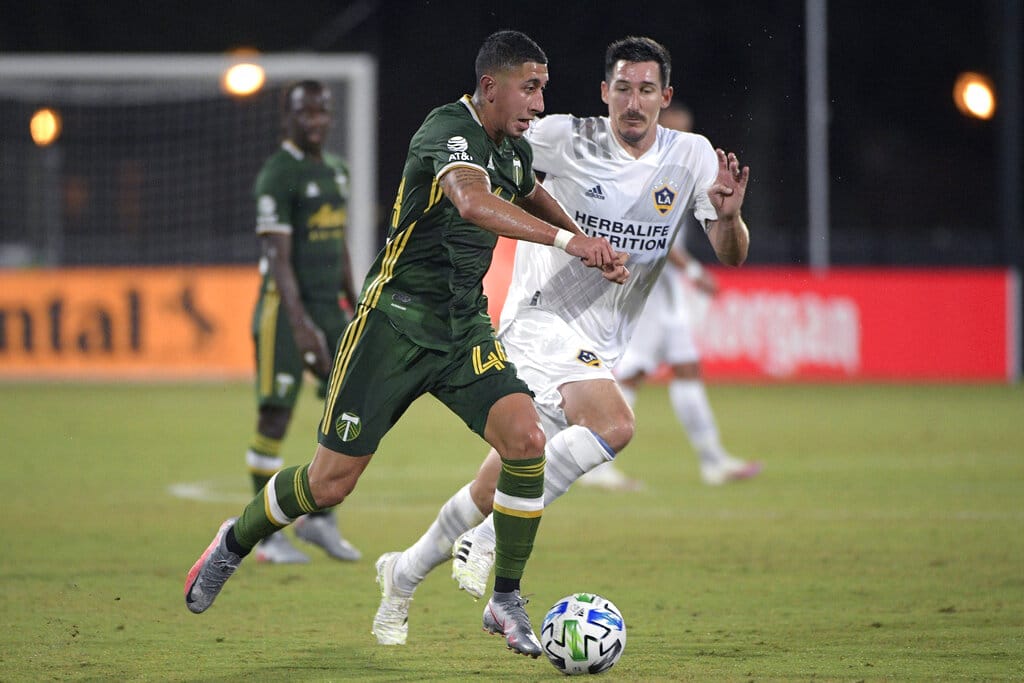 Portland Timbers midfielder Marvin Loria (44) controls the ball in front of LA Galaxy midfielder Sacha Kljestan during the first half of an MLS soccer match Monday, July 13, 2020, in Kissimmee, Fla. (AP Photo/Phelan M.
