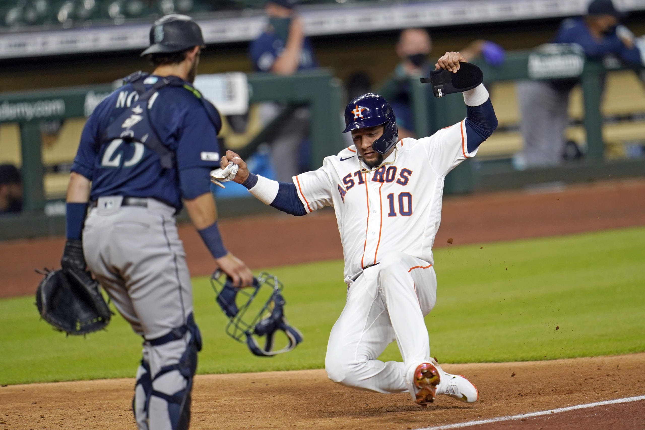 Houston Astros' Yuli Gurriel (10) scores as Seattle Mariners catcher Austin Nola looks on during the seventh inning of a baseball game Friday, July 24, 2020, in Houston. (AP Photo/David J.