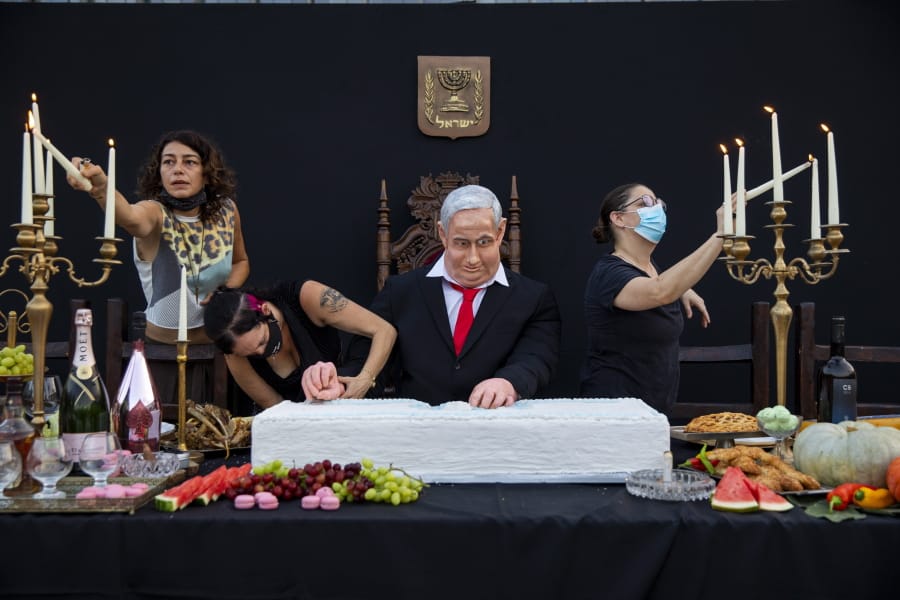 Team members of Israeli artist Itay Zalait, work on an installation depicting Prime Minister Benjamin Netanyahu at a mock &quot;Last Supper&quot; at Rabin square in Tel Aviv, Israel, Wednesday, July 29, 2020. The installation, placed in a central Tel Aviv square on Wednesday, in the latest twist in a summer of protests against Netanyahu and his lengthy rule.