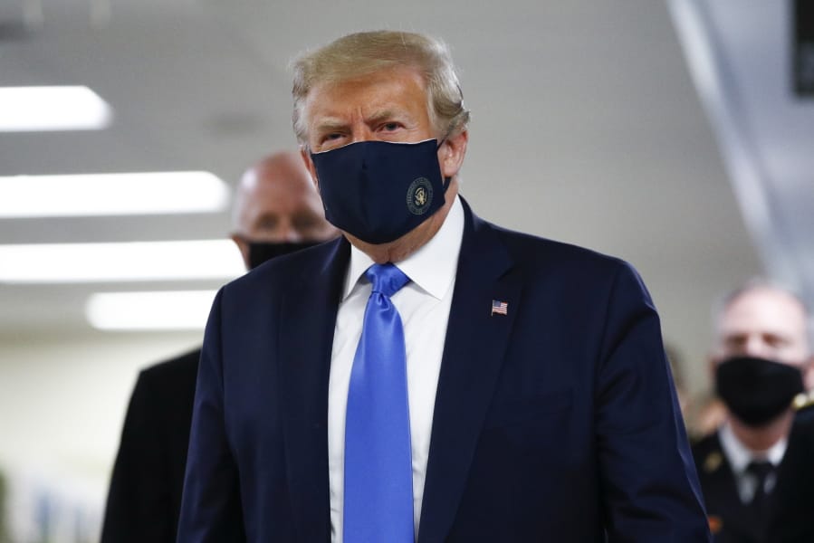 President Donald Trump wears a mask as he walks down the hallway during his visit to Walter Reed National Military Medical Center in Bethesda, Md., Saturday, July 11, 2020.