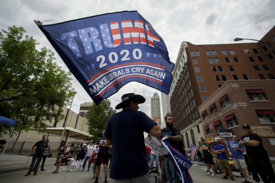 FILE - In this June 20, 2020, file photo a supporter waves a flag prior to a campaign rally for President Trump at the BOK Center in Tulsa, Okla. A new poll from The Associated Press-NORC Center for Public Affairs Research finds that Joe Biden&#039;s supporters are less enthusiastic than President Donald Trump&#039;Aos, both about the campaign itself and their candidate.