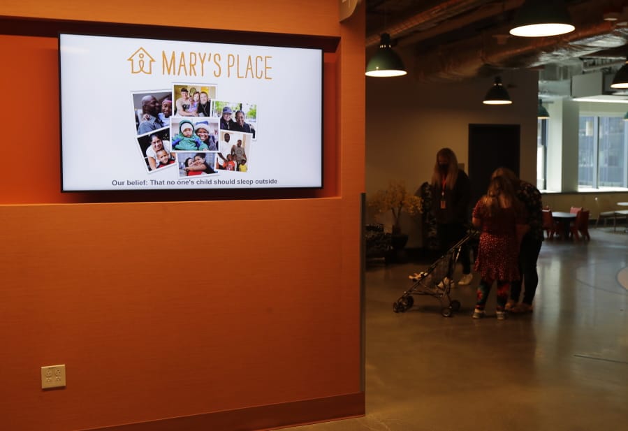 A June 17 video display shows photos and the logo for Mary&#039;s Place, a family homeless shelter located inside an Amazon corporate building on the tech giant&#039;s Seattle campus.