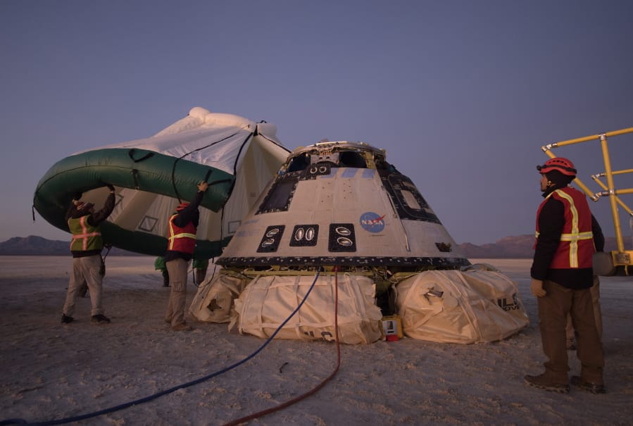 Boeing, NASA, and U.S. Army personnel work around the Boeing Starliner spacecraft shortly after it landed Dec. 22 in White Sands, N.M. On July 7, NASA officials said they have identified 80 corrective actions for safety, mostly involving software, that must be implemented before the Starliner capsule launches again.