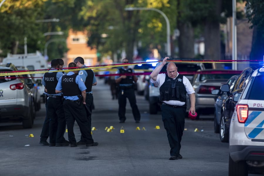 Chicago police officers investigate the scene of a deadly shooting in Chicago on Sunday, July 5, 2020, where a 7-year-old girl and a man were fatally shot during a Fourth of July party Saturday. At least a dozen people were killed in Chicago over the Fourth of July weekend, police said. Scores of people were shot and wounded.