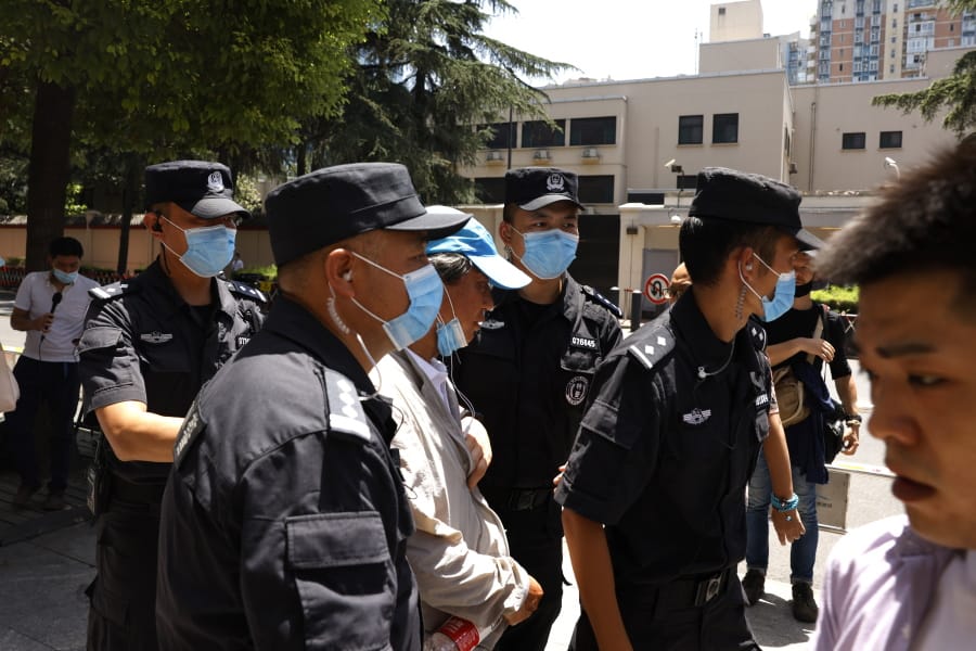 Chinese SWAT police officers escort away a man who tried to show protest slogans on his shirt outside the former United States Consulate in Chengdu in southwest China&#039;s Sichuan province on Monday, July 27, 2020. Chinese authorities took control of the former U.S. consulate in the southwestern Chinese city of Chengdu on Monday after it was ordered closed in retaliation for a U.S. order to vacate the Chinese Consulate in Houston.
