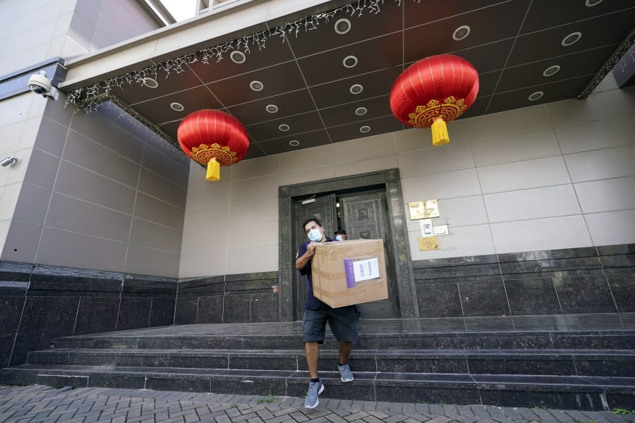 A FedEx employee removes a box from the Chinese Consulate Thursday, July 23, 2020, in Houston. China says &quot;malicious slander&quot; is behind an order by the U.S. government to close its consulate in Houston,  and maintains that its officials have never operated outside ordinary diplomatic norms.  (AP Photo/David J.