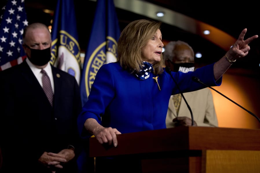 House Speaker Nancy Pelosi of Calif., accompanied by Rep. Dan Kildee, D-Mich., left, and Rep. Danny Davis, D-Ill., right, speaks at a news conference on Capitol Hill in Washington, Friday, July 24, 2020, on the extension of federal unemployment benefits.