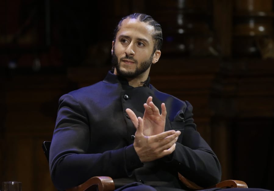 FILE - NFL football quarterback Colin Kaepernick applauds during W.E.B. Du Bois Medal ceremonies at Harvard University in Cambridge, Mass. on Oct. 11, 2018. Kaepernick has been condemned by President Donald Trump and others on the right and had not played an NFL game since 2016, when he began kneeling during the National Anthem to protest &quot;a country that oppresses black people and people of color.&quot; But he has appeared in Nike advertisements, been honored by the ACLU and Amnesty International among other organizations and reached an agreement with the Walt Disney Co. for a docuseries about this life.