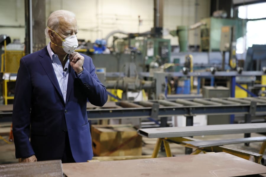 FILE - In this July 9, 2020, file photo Democratic presidential candidate, former Vice President Joe Biden adjusts his mask during a tour of McGregor Industries, a metal fabricating facility in Dunmore, Pa. Biden is pledging to define his presidency by a sweeping economic agenda beyond anything Americans have seen since the Great Depression and the industrial mobilization for World War II.