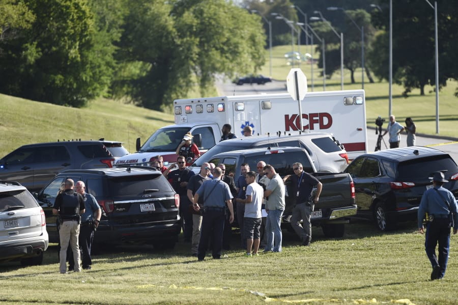 Law enforcement agents confer near the site of a shooting Thursday, July 2, 2020, in Kansas City, Mo. The shooting left a suspect dead and a police officer in critical condition after being shot in the head. The officer was hospitalized for emergency surgery, Kansas City police said on Twitter.