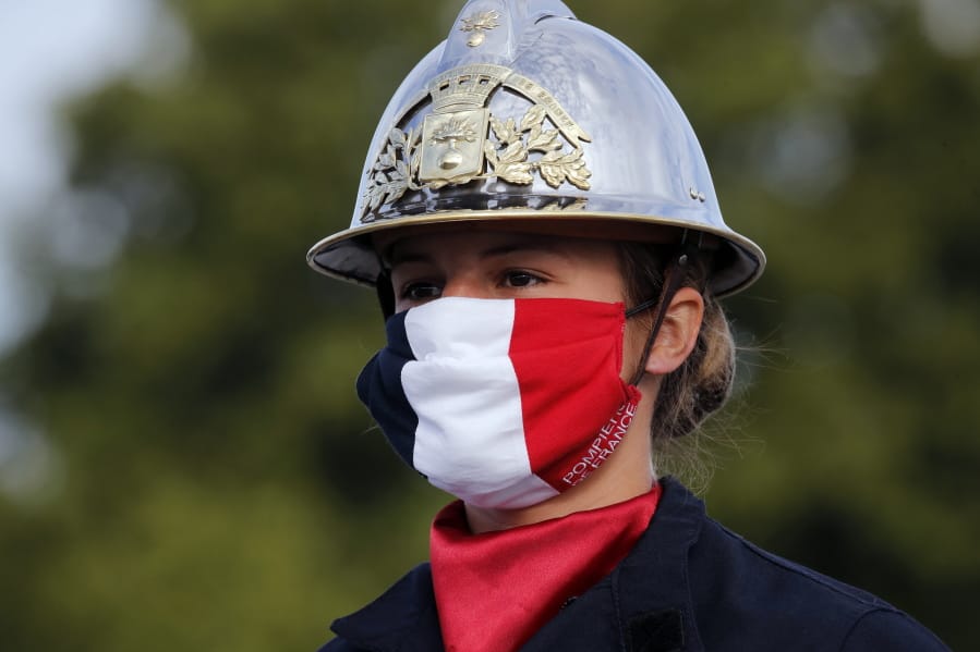 A firefighter wears a face mask with the colors of the French flag, prior to the Bastille Day parade Tuesday, July 14, 2020 on the Champs Elysees avenue in Paris. France are honoring nurses, ambulance drivers, supermarket cashiers and others on its biggest national holiday Tuesday. Bastille Day&#039;s usual grandiose military parade in Paris is being redesigned this year to celebrate heroes of the coronavirus pandemic.