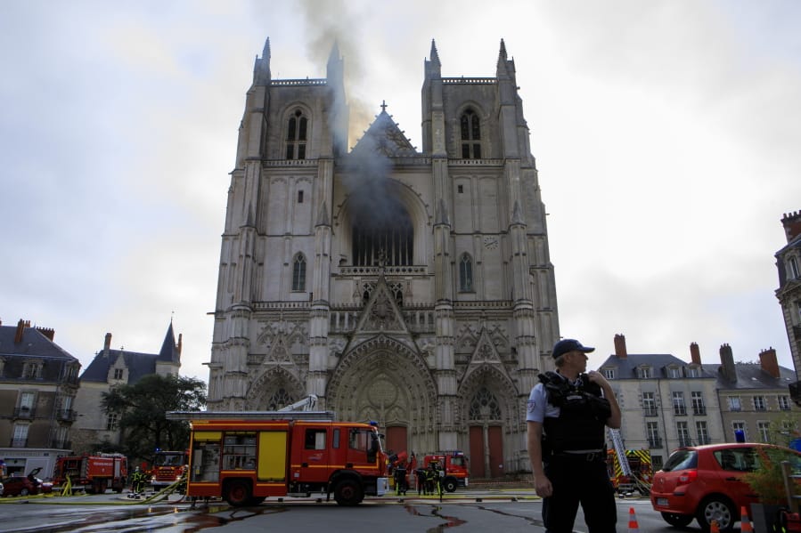 Fire fighters brigade work to extinguish the blaze at the Gothic St. Peter and St. Paul Cathedral, in Nantes, western France, Saturday, July 18, 2020. The fire broke, shattering stained glass windows and sending black smoke spewing from between its two towers of the 15th century, which also suffered a serious fire in 1972. The fire is bringing back memories of the devastating blaze in Notre Dame Cathedral in Paris last year that destroyed its roof and collapsed its spire and threatened to topple the medieval monument.