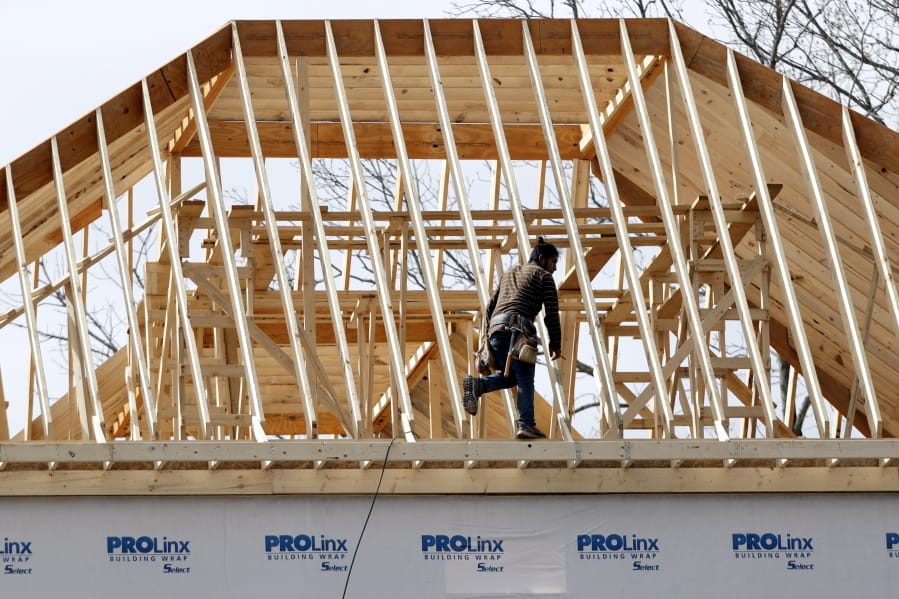 In this March 25, 2020, photo, a construction worker walks along a roof on a new home in Nashville, Tenn.  US home construction rebounded 4.3% in May after steep declines caused by shutdowns due to the coronavirus.
