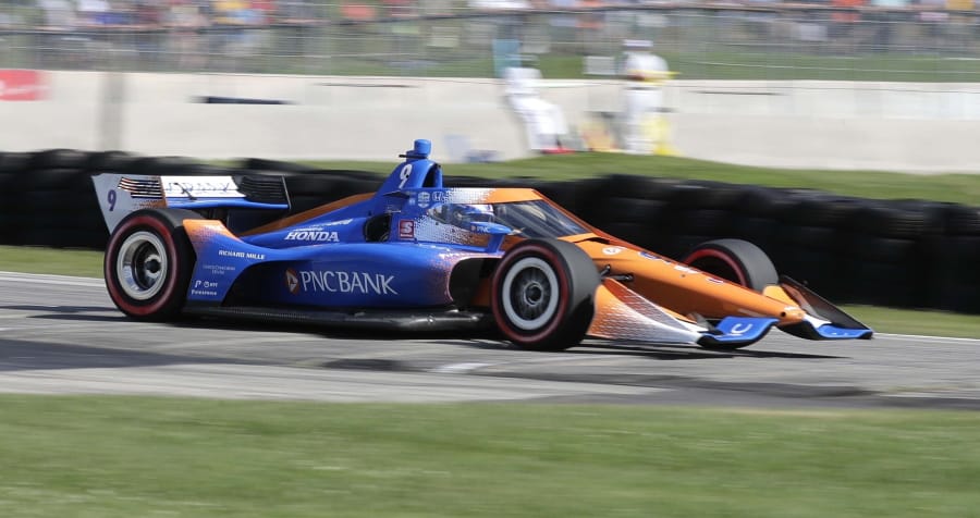 IndyCar driver Scott Dixon (9) is a blur of speed as he exits Turn 5 during the REV Group Grand Prix on Saturday at Elkhart Lake, Wis. Dixon went on to win the event. (Gary C.
