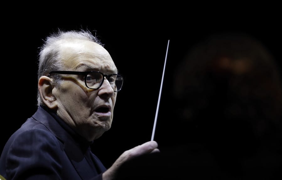 FILE - In this file photo dated Tuesday, March 6, 2018, Italian composer Ennio Morricone directs an ensemble during a concert of his &quot;60 Year Of Music World Tour&quot;, in Milan, Italy. Morricone, who created the coyote-howl theme for the iconic Spaghetti Western &quot;The Good, the Bad and the Ugly&quot; and the soundtracks such classic Hollywood gangster movies as &quot;The Untouchables,&quot; died Monday, July 6, 2020 in a Rome hospital at the age of 91.