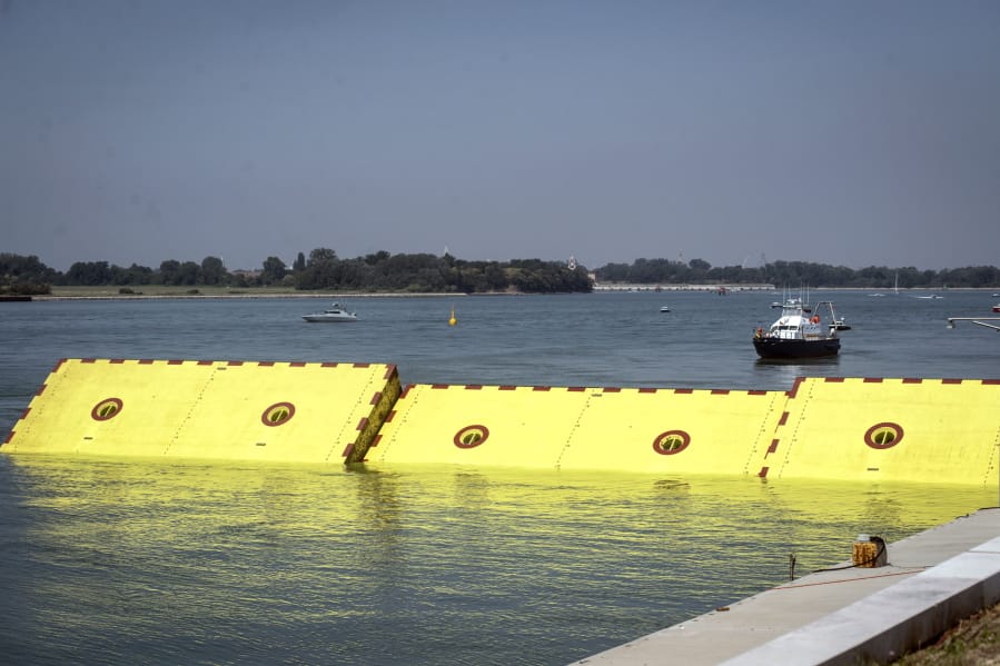 Moveable flood gates rise from the sea in the Venice lagoon, Italy, Friday, July 10, 2020. Venice has conducted a trial run an ambitious anti-flood system of 78 inflatable barriers in the hopes of protecting the lagoon city from devastating high tides. Premier Giuseppe Conte on Friday at a ceremony in Venice pressed a button that activated compressors to pump air into the bright yellow barriers, which then started rising from the sea to act a kind of a dike-on-demand.