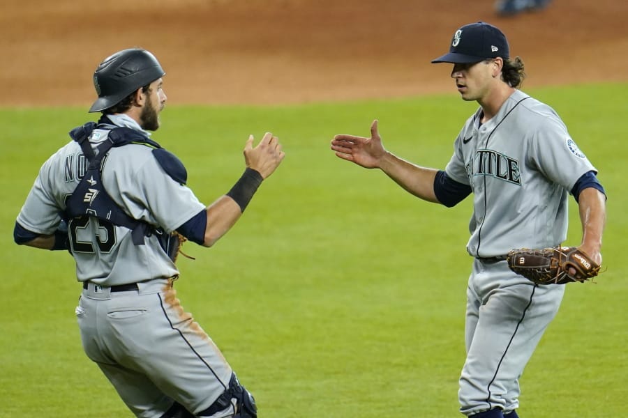 Seattle Mariners relief pitcher Taylor Williams, right, celebrates with catcher Austin Nola after a baseball game against the Houston Astros Sunday, July 26, 2020, in Houston. The Mariners won 7-6. (AP Photo/David J.