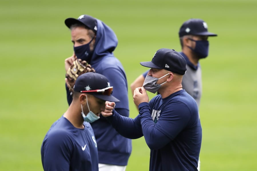 Seattle Mariners&#039; Kyle Seager, second right, and teammates wear masks as they walk on the field at baseball practice Tuesday, July 7, 2020, in Seattle.