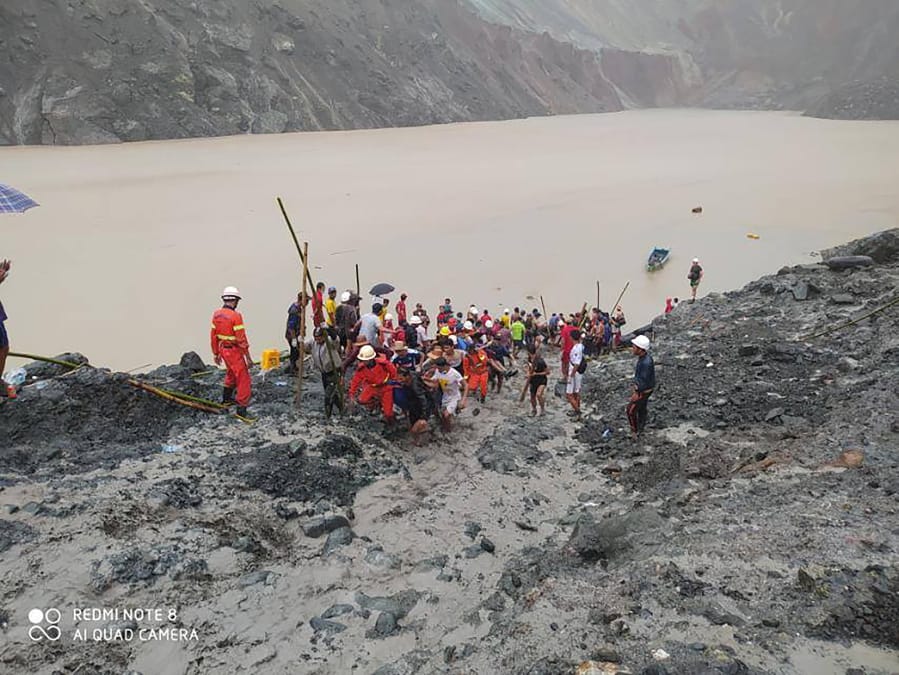 In this photo released from Myanmar Fire Service Department, rescuers carry a recovered body of a victim in a landslide from a jade mining area in Hpakant, Kachin state, northern Myanmar Thursday, July 2, 2020. Myanmar government says a landslide at a jade mine has killed dozens of people.
