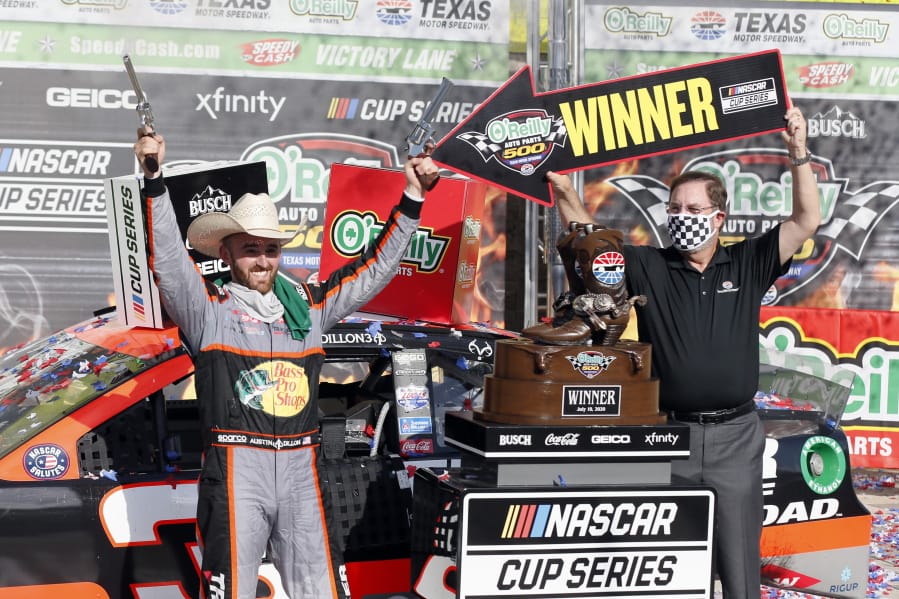 Texas Motor Speedway President and General Manager Eddie Gossage, right, holds a &quot;winner&quot; sign as Austin Dillon, left, celebrates by firing six shooters after winning the NASCAR Cup Series auto race at Texas Motor Speedway in Fort Worth, Texas, Sunday, July 19, 2020.