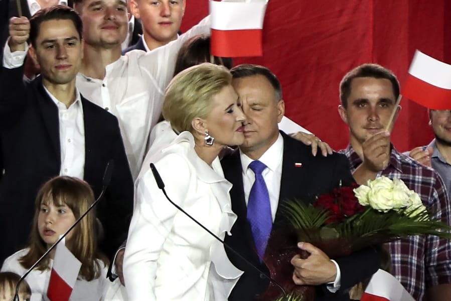 Incumbent President Andrzej Duda is hugged by his wife Agata Kornhauser-Duda in Pultusk, Poland, Sunday, July 12, 2020.