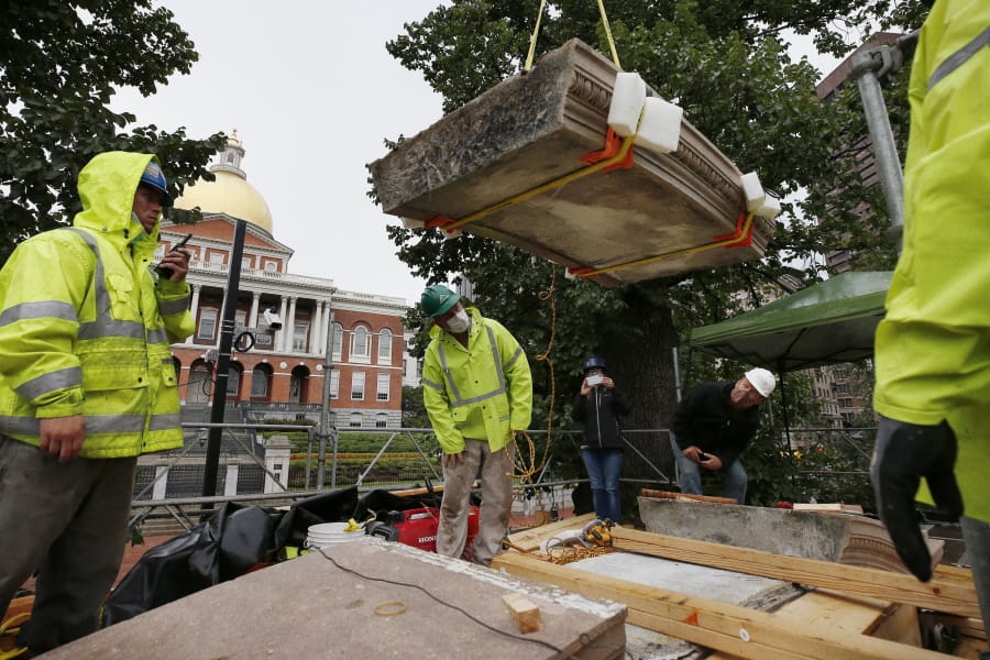 Workers inspect the top cornice stone as it is lifted from the Shaw 54th Regiment memorial opposite the Statehouse, Friday, July 17, 2020, in Boston. Amid the national reckoning on racism, the memorial to the first Black regiment of the Union Army, the Civil War unit popularized in the movie &quot;Glory,&quot; is facing scrutiny.