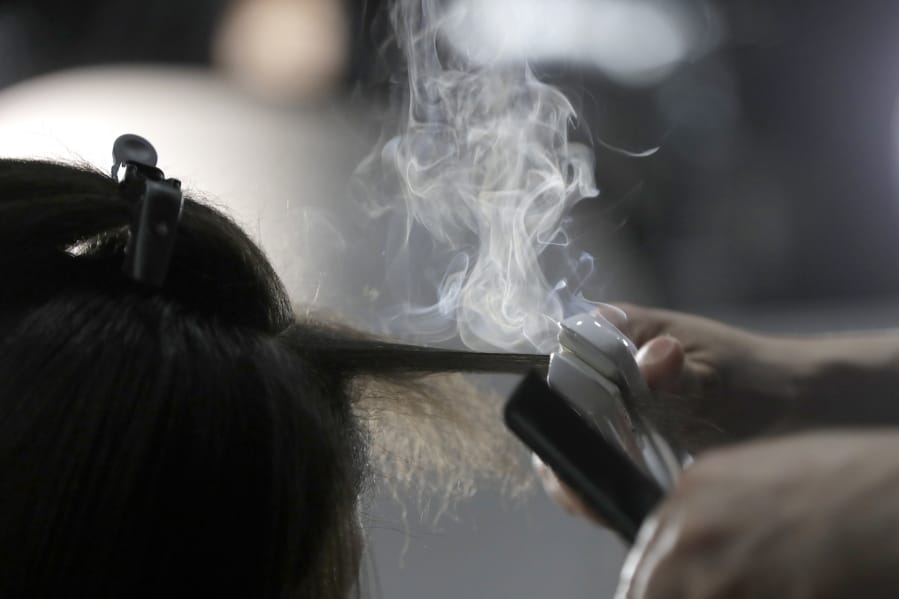 FILE - Steam rises as a hair stylist works on a model prior to a show displaying the Tom Ford collection during Fashion Week on Feb. 6, 2019, in New York. People of color in the industry trace bias and discrimination in predominantly white salons to the sidelining of formal education focused on Black hair. Horror stories are not uncommon, from outright refusal of service to botched treatments and cuts by stylists who don&#039;t know what they&#039;re doing.