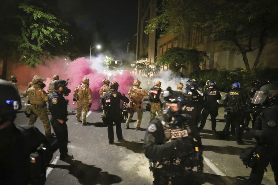 Police respond to protesters during a demonstration,  Friday, July 17, 2020 in Portland, Ore. Militarized federal agents deployed by the president to Portland, fired tear gas against protesters again overnight as the city&#039;s mayor demanded that the agents be removed and as the state&#039;s attorney general vowed to seek a restraining order against them.