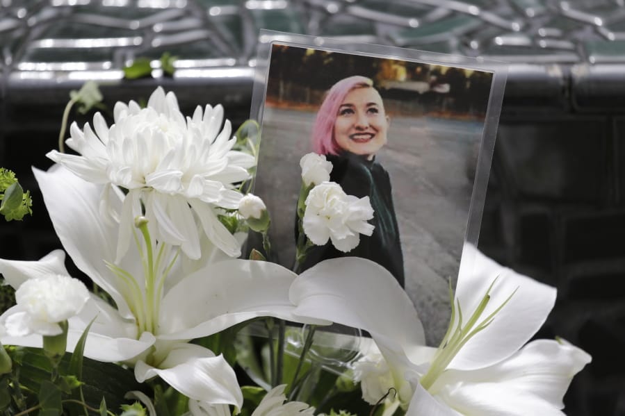 A photo of Summer Taylor, who suffered critical injuries and died after being hit by a car while protesting over the weekend, sits among flowers at the King County Correctional Facility where a hearing was held for the suspect in their death Monday, July 6, 2020, in Seattle. Dawit Kelete is accused of driving a car on to a closed Seattle freeway and hitting two protesters, killing one, over the weekend. Seattle has been the site of prolonged unrest over the death of George Floyd, a Black man who was in police custody in Minneapolis, and had shut down the interstate for 19 days in a row.